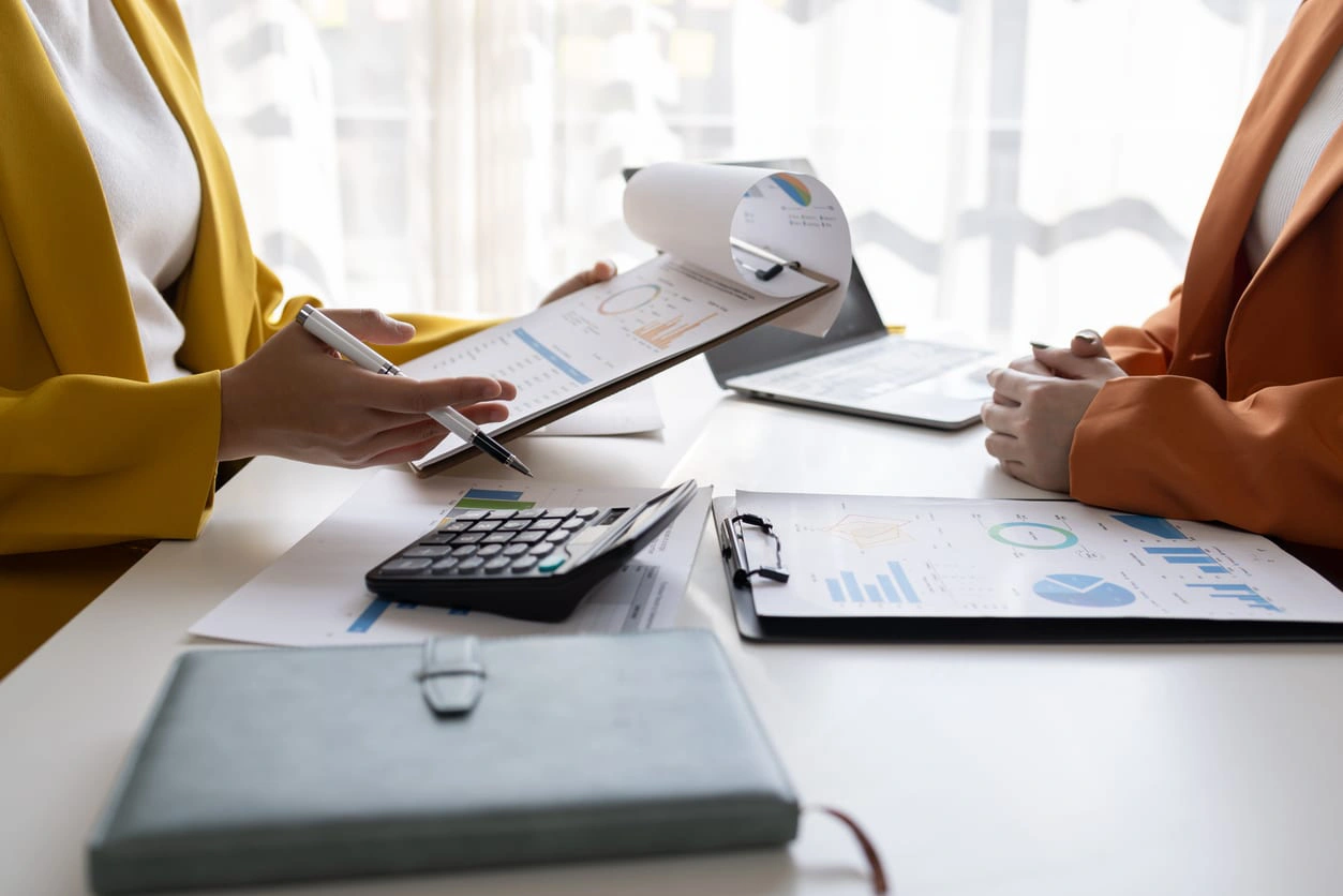 business women working on desk office with using a calculator to calculate the numbers tax, finance accounting research or financial strategy